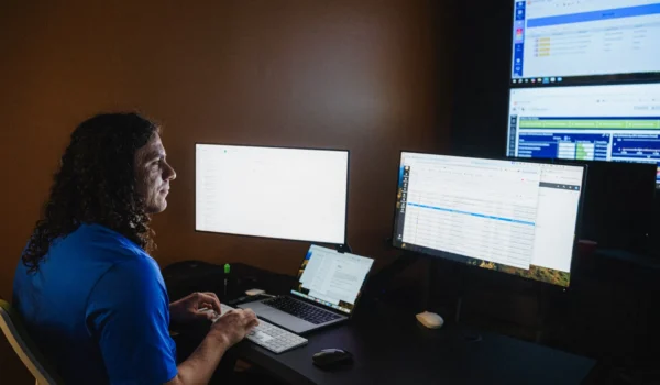 Security analyst monitoring dashboards across multiple screens in a dark operations room