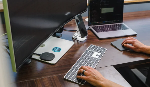 IT professional working at a multi-monitor desk setup, representing enterprise cybersecurity operations