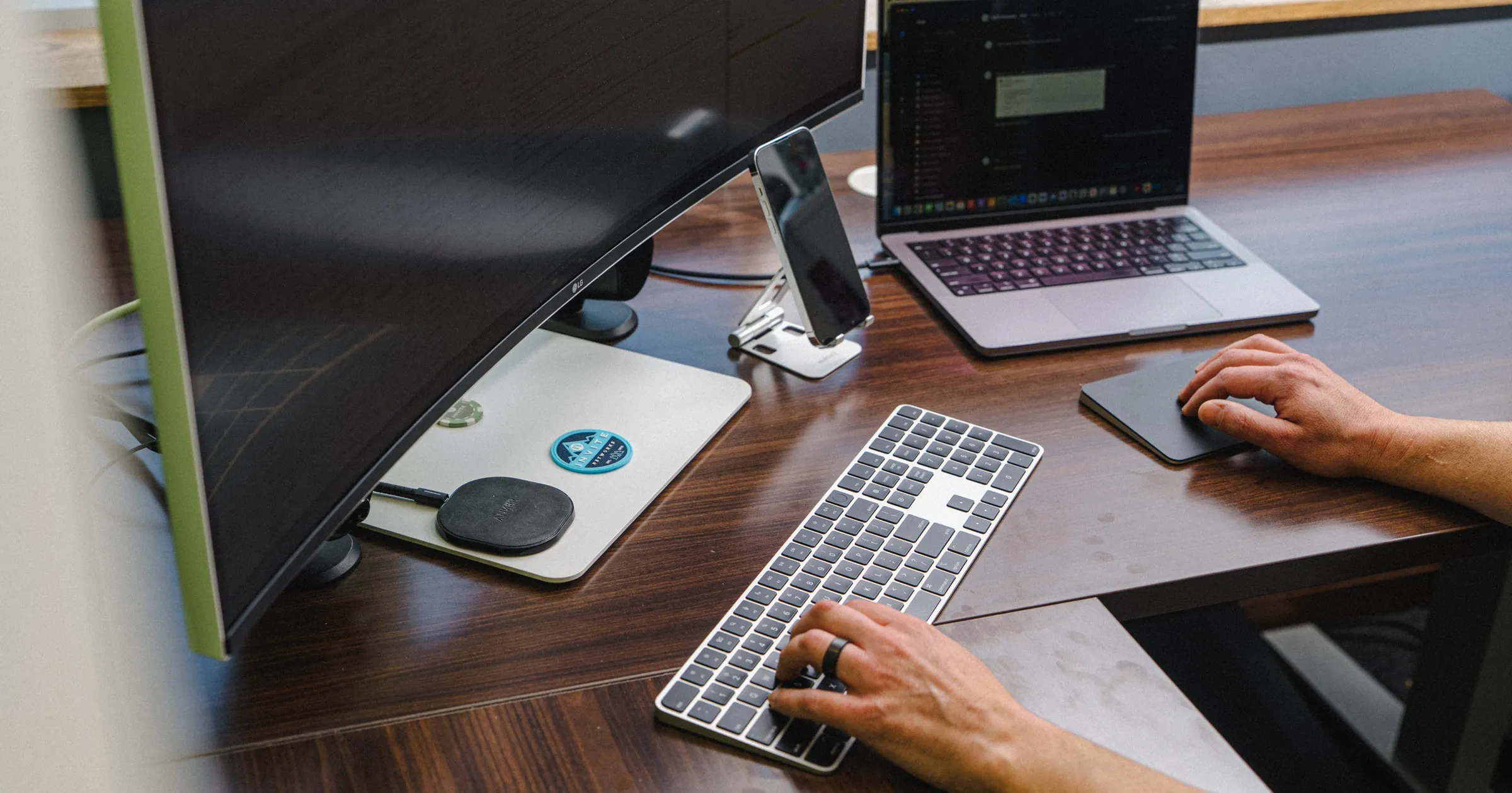 IT professional working at a multi-monitor desk setup, representing enterprise cybersecurity operations
