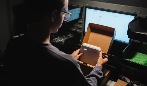 INVITE Networks technician provisioning a network device at a workstation, representing Cato Networks SASE deployment and management