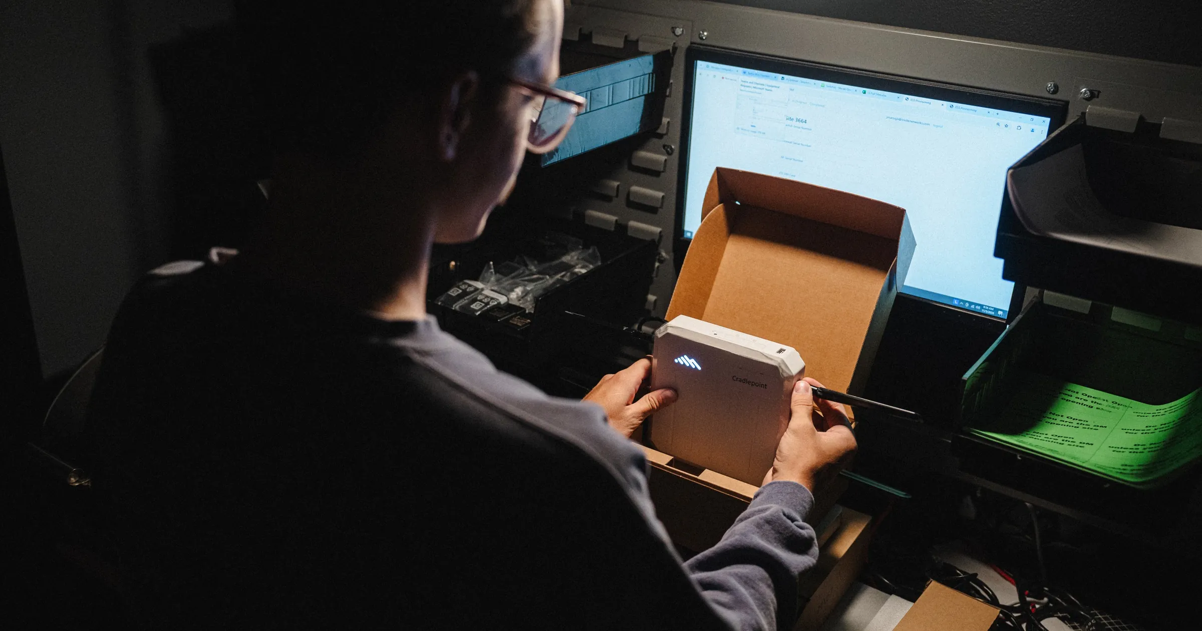 INVITE Networks technician provisioning a network device at a workstation, representing Cato Networks SASE deployment and management
