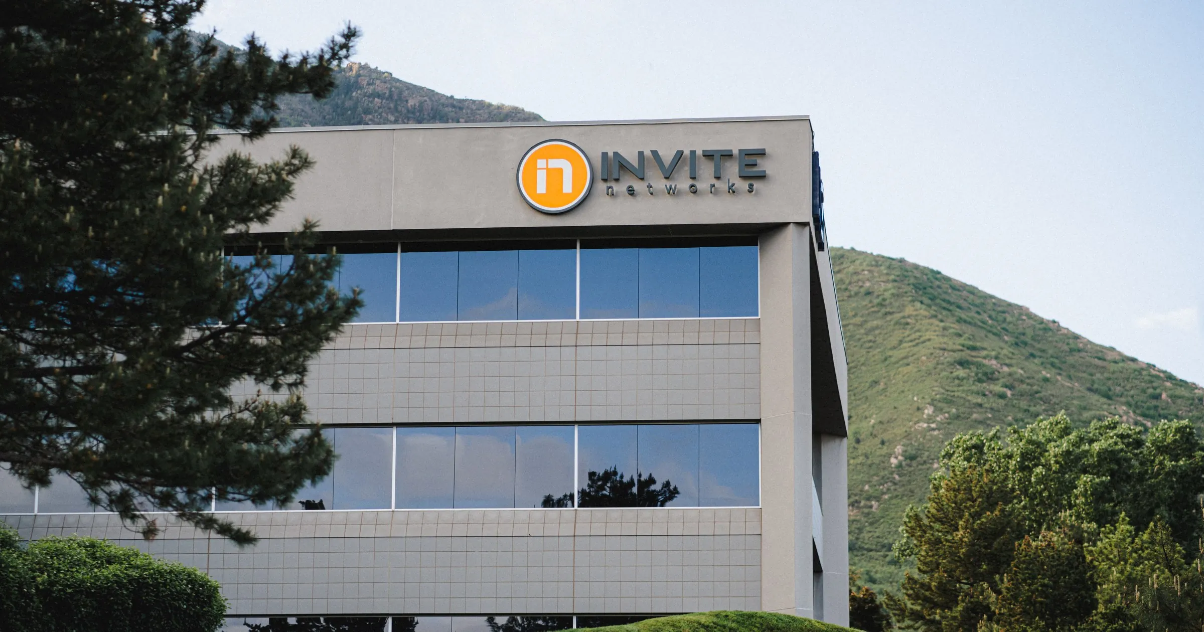 INVITE Networks headquarters building with the INVITE logo against the Wasatch foothills